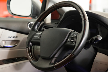 Fototapeta na wymiar View to the black color interior of suv car with front seats, steering wheel and dashboard with gray leather upholstery after cleaning and detailing in vehicle repair workshop. Auto service industry.