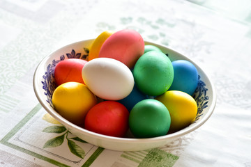 A simple moments of real life - a cup with painted Easter eggs on a table in a country house,