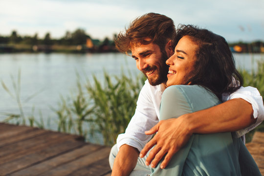 Young couple in love flirting by the river during the summer