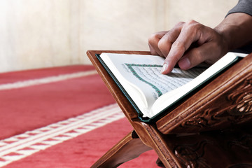 Muslim man reading holy quran in mosque