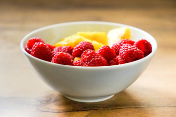 Ananasstücke und Himbeeren in einer Schale