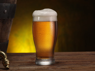 Chilled glass of beer on the wooden table. Close-up. Craft brewery.
