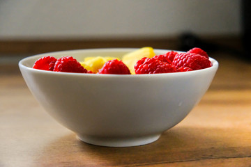 Ananasstücke und Himbeeren in einer Schale