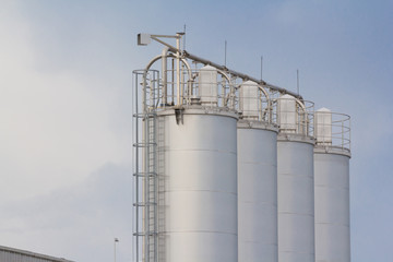 industry stainless steel silos. metal container with steel cage ladder.