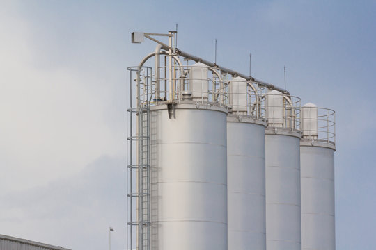 industry stainless steel silos. metal container with steel cage ladder.