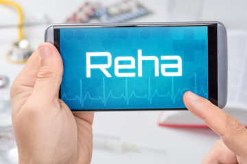 Smartphone mit dem Text Reha auf dem Display