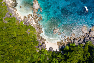 Aerial view of a small bay on a beautiful tropical island with coral reef and granite boulders