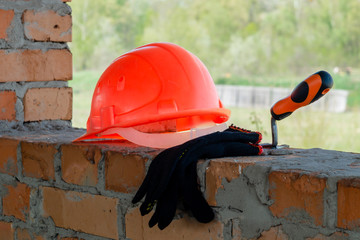 A pair of gloves and a Mason's helmet at the construction.