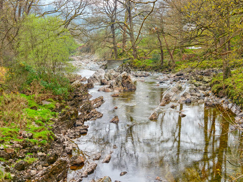 The clear water of the  River Mawddach flows gently over rocks