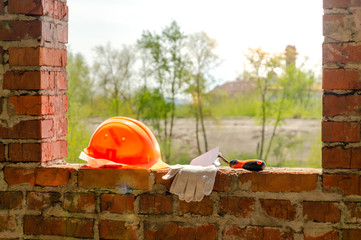 A pair of gloves and a Mason's helmet at the construction.