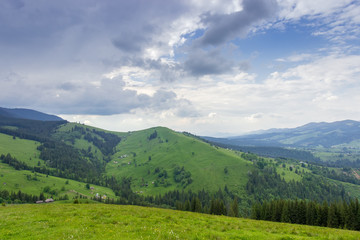 Fototapeta na wymiar Mountain village scattered on the slopes of valley in Carpathians