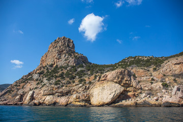 Beautiful view from water at yellow and orange Crimean mountain landscape near Balaklava at sea coast. Summer travel and journey