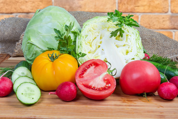Various fresh vegetables and herbs on a wooden surface