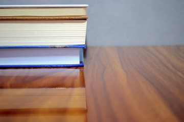group of books on a wooden table with grey background  