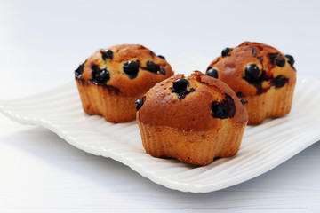 Muffins with black currant on a white background, horizontal photo