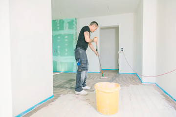 Haus im Bau.  Fussboden oberfläche grundieren und nivellieren.