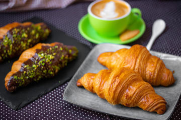 french breakfast. coffee with croissant. Cappuccino in a green cup with croissant.