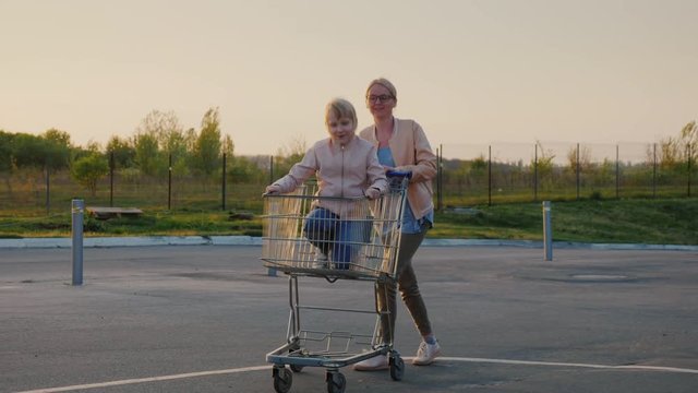 Mom rolls her daughter in a shopping basket