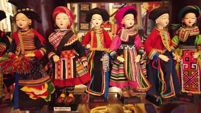 Gimbal close details uthentic wooden porcelain dolls in colorful historical costumes traditional Asia Vietnam. Handmade piece of art souvenirs gifts bazaar market.