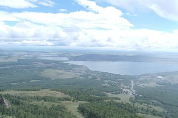Fototapeta na wymiar panoramic view from the top of the mountain to the mountain expanses with a lake