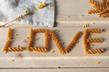pasta spiral in the form of inscription love on a wooden table