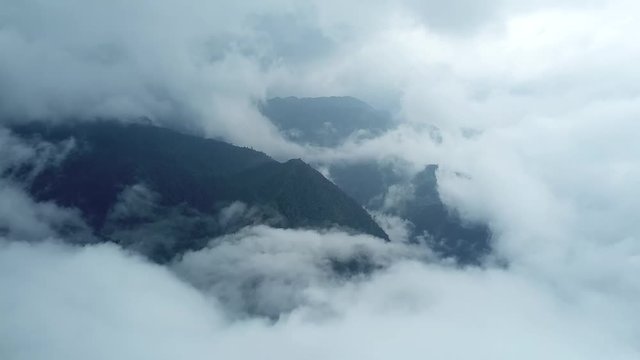 Helicopter flight in stormy clouds. Great high mountains forest. Summer thunderstorm epic nature disaster. Aerial drone
