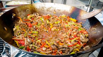 Closeup image of fryung vegetables and meat in the wok pan