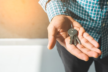 Close up hand holding key in house.