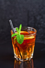 Traditional fresh iced tea with lemon, mint leaves and ice cubes in glass.