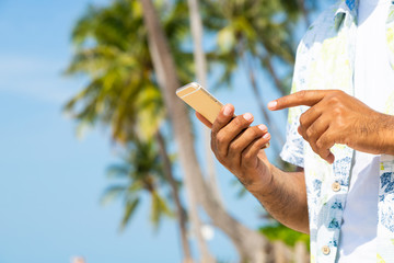 Man on the beach using smartphone.