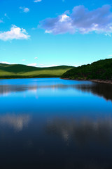 Fototapeta na wymiar Beautiful lake with specular shine in soft mountains 