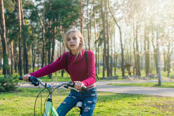 Naklejka premium Teenager girl on a bicycle in the park.