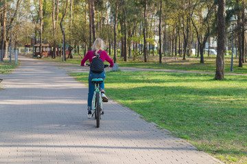 Fototapeta premium Teenager girl on a bicycle in the park.
