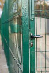 A metal door fence with a lock.