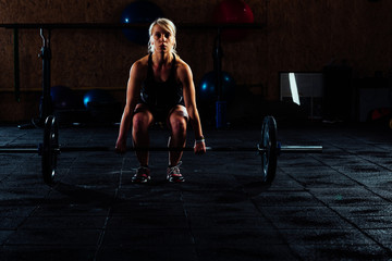 Girl in the gym training with weights