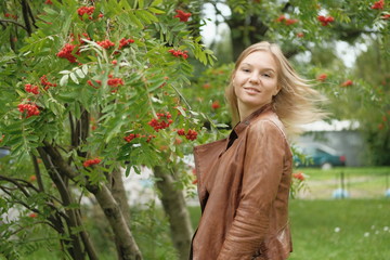 Beautiful blond girl posing for photo in park with wildberry