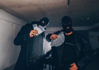 Masked thieves holding revolvers and showing off their catch