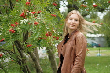 Beautiful blond girl posing for photo in park with wildberry