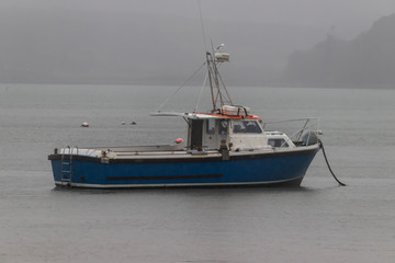 Small fishing boat anchored offshore 