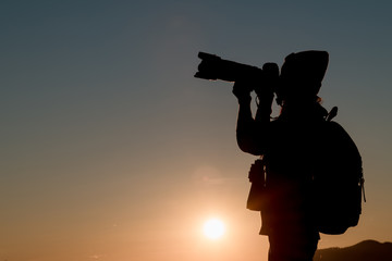 The silhouette of a young womanl on the mountain at sunset