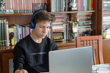 The teenage is  listening to music at home