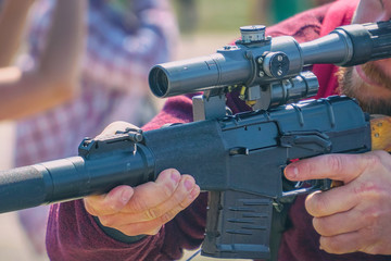 Rifle with an optical sight in hands of men