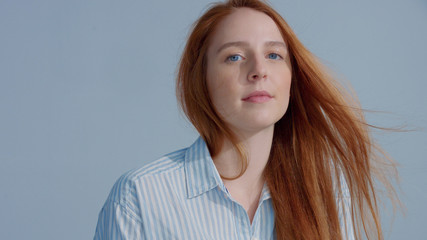 closeup portrait of ginger head model in studio with blowing hair