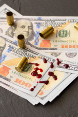 spat blood on hundred dollar bills and fire arm cartridges crime dirty money concept