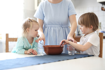 Little sibling with mother make linen flour dough