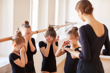 Group of little girls crying during ballet practice in studio lit by warm sunlight, copy space