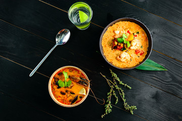 Tom Yam kung Spicy Thai soup with shrimp, seafood, coconut milk and chili pepper in bowl copy space