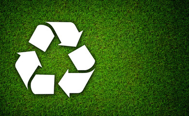 White Symbol Recycle on green grass background- Ecology concept