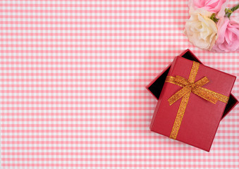gift box with red isolated on Plaid background. Holiday decoration for Mother's Day or Women's Day.