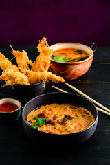 Close up of a bowl of Thai spicy seafood tom yum noodle with shrimp, squid, fish and New Zealand mussel.